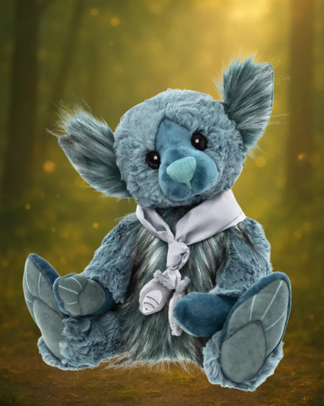 A Charlie Bears collectible teddy bear in soft blue-grey plush.