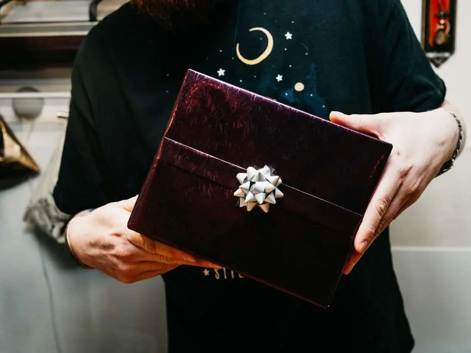 A gift box wrapped in deep burgundy paper finished with a bow.